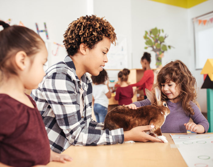 Teacher showing young kids a rabbit
