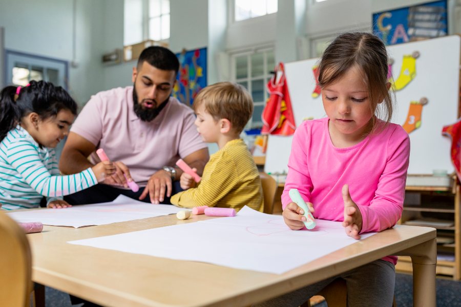 children painting with teacher's help