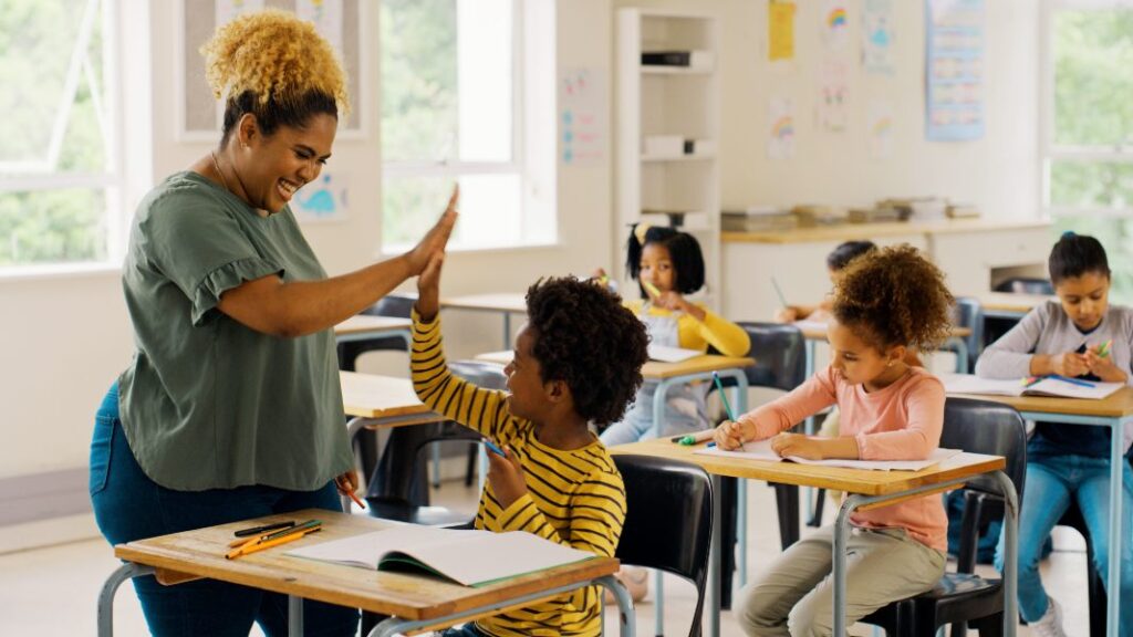Teacher high-fiving children in a classroom in Laurel, NJ. 