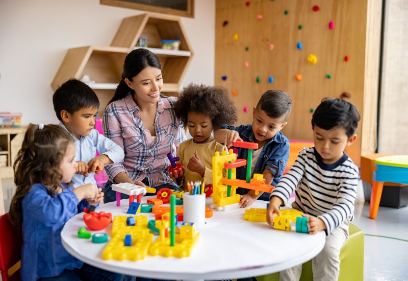 Kids playing fun classic games indoors with a teacher at daycare in Bensalem, PA.
