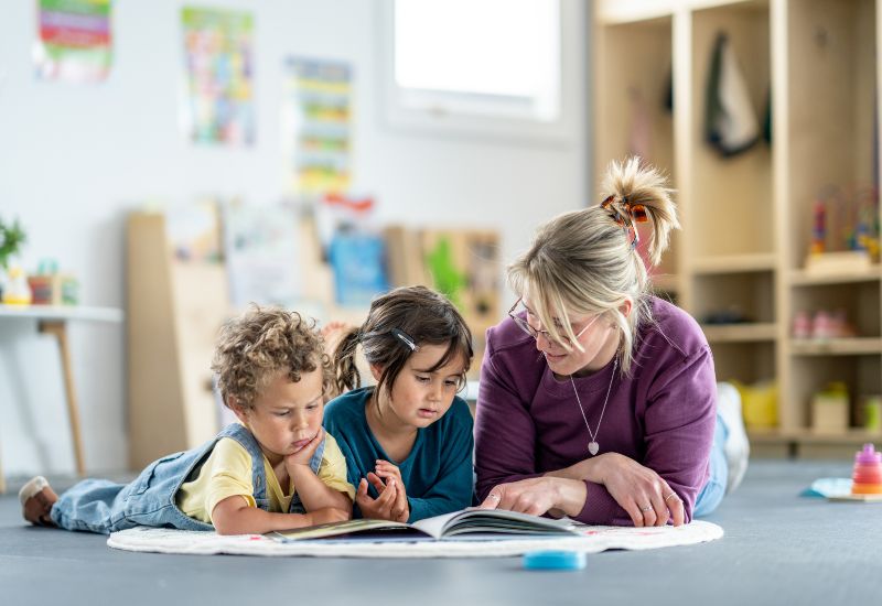 A teacher reads with children while explaining transitional kindergarten readiness in Bensalem, PA.