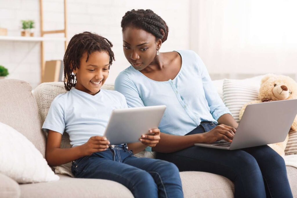 Child and caregiver reviewing content on a tablet to promote safe and balanced technology use